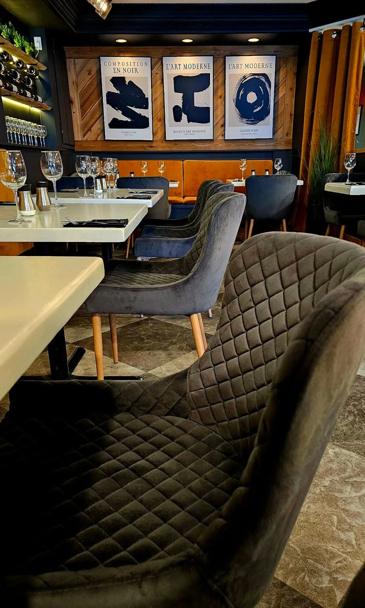 Quilted dining chairs, white tabletops and framed artwork in Trio’s dining room